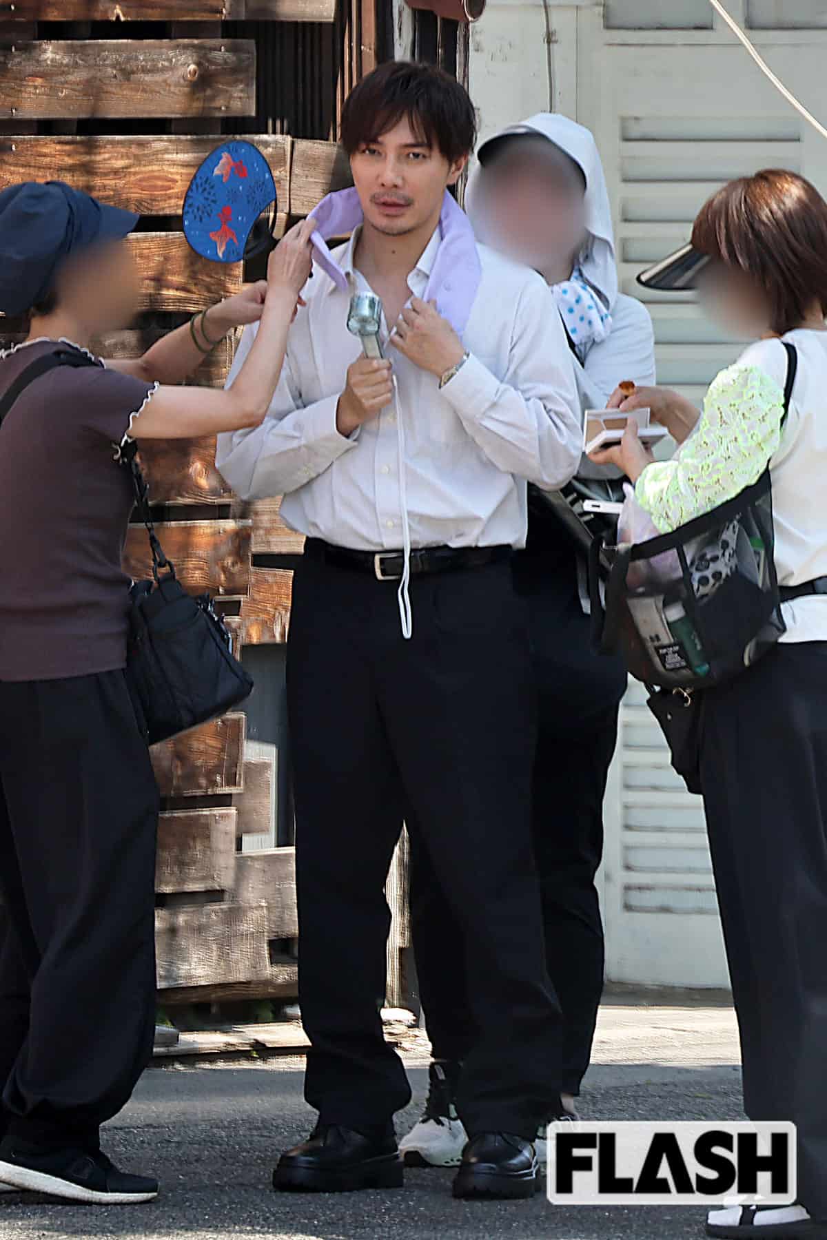 酷暑の中、ロケの合間に涼む成宮寛貴。その様子もサマになっている（写真・吉田 豊）
