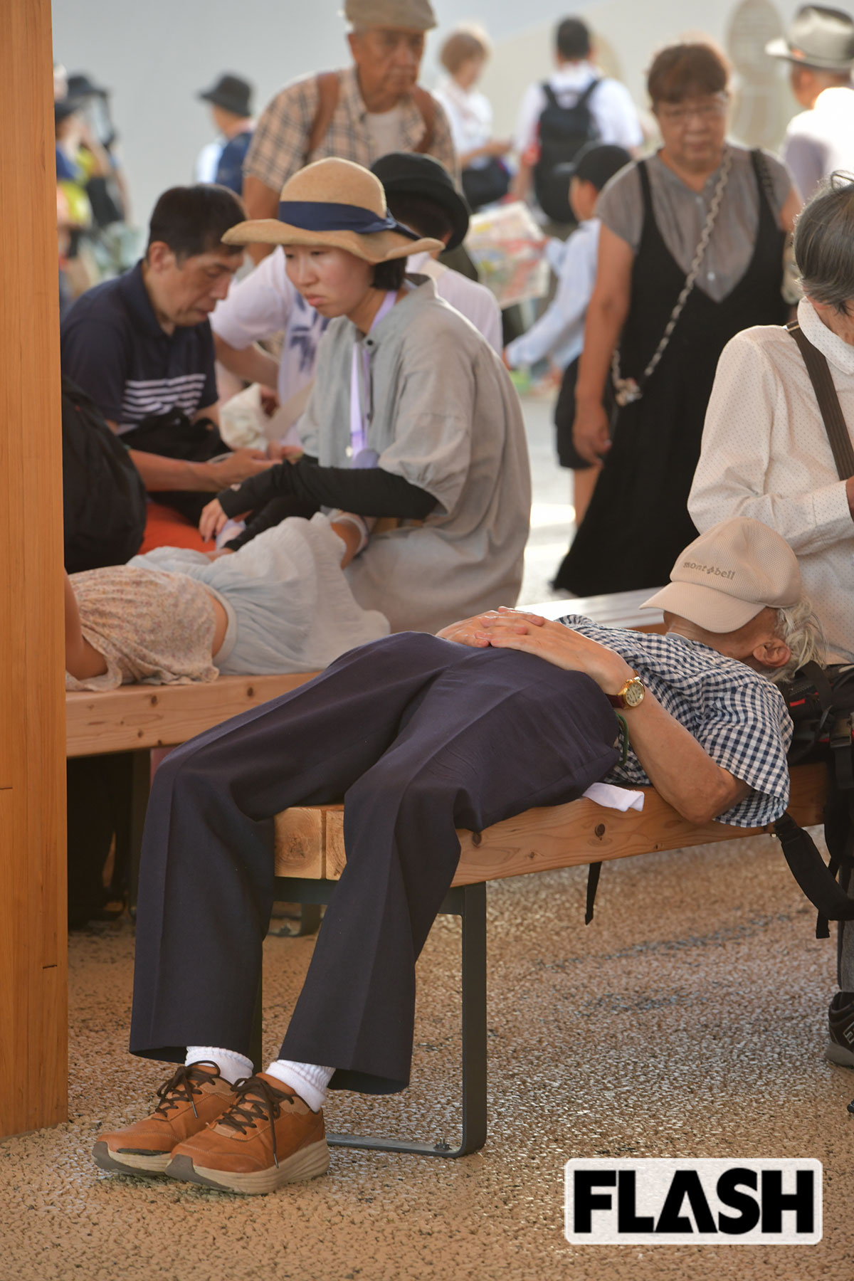 大屋根リング下では、暑さの影響かぐったりとしている人が（写真・馬詰雅浩）