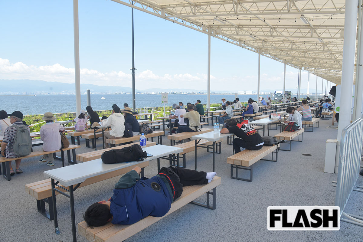海辺で涼みながら休憩している来場者たち（写真・馬詰雅浩）