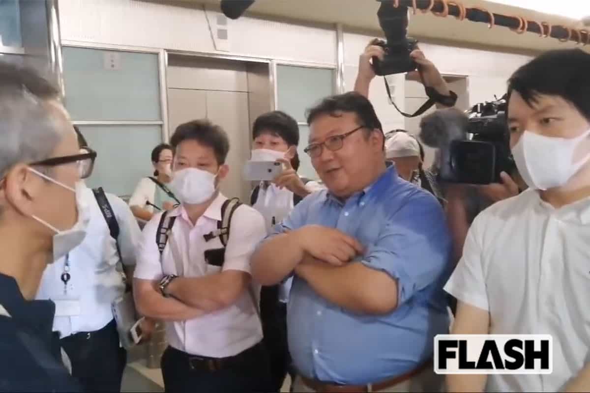 会見会場の受付で、三宅勝久氏(左)、筆者らを排除する青潮会メンバー