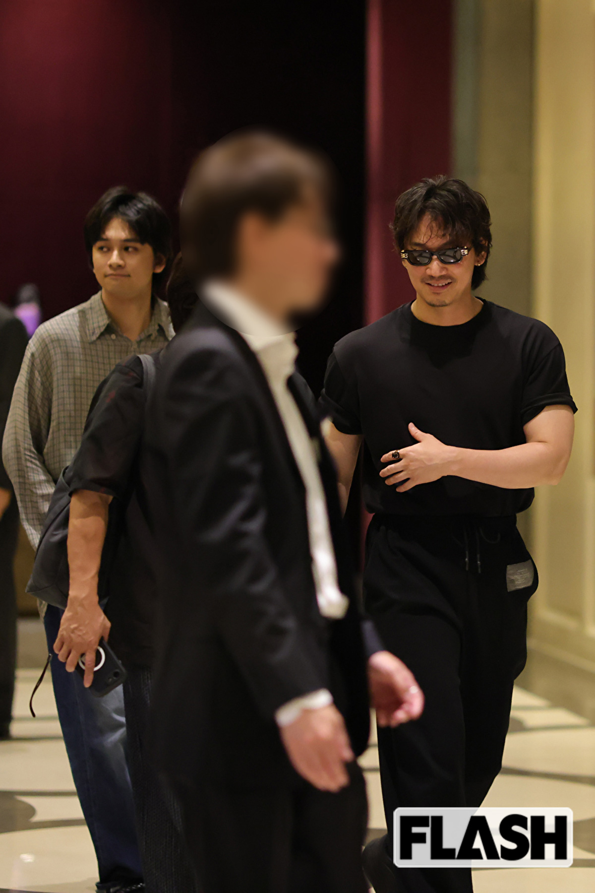 北村匠海とともにホテルに戻った綾野剛。ぴっちりしたTシャツからムキムキの腕が見える