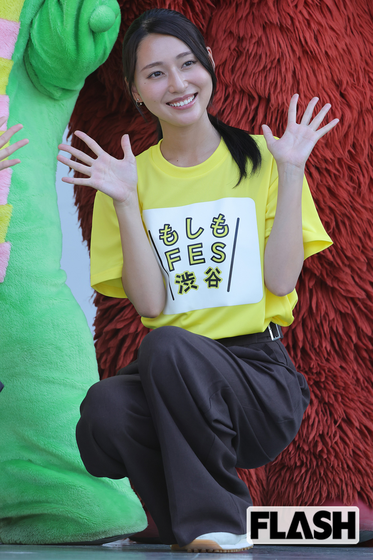 手のひらを見せて笑顔の宮本真綾アナ