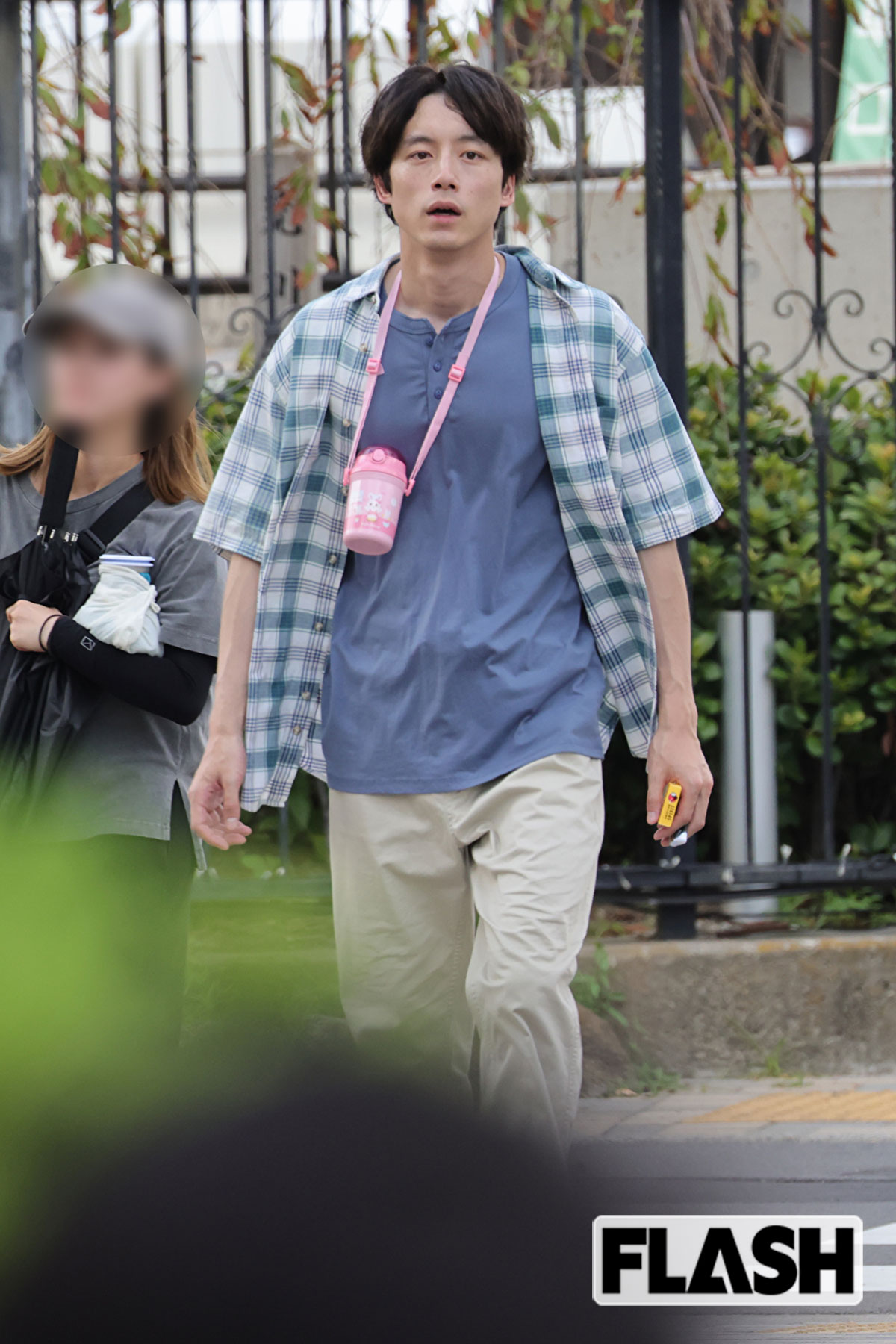 ピンク色の水筒を首から下げた坂口健太郎