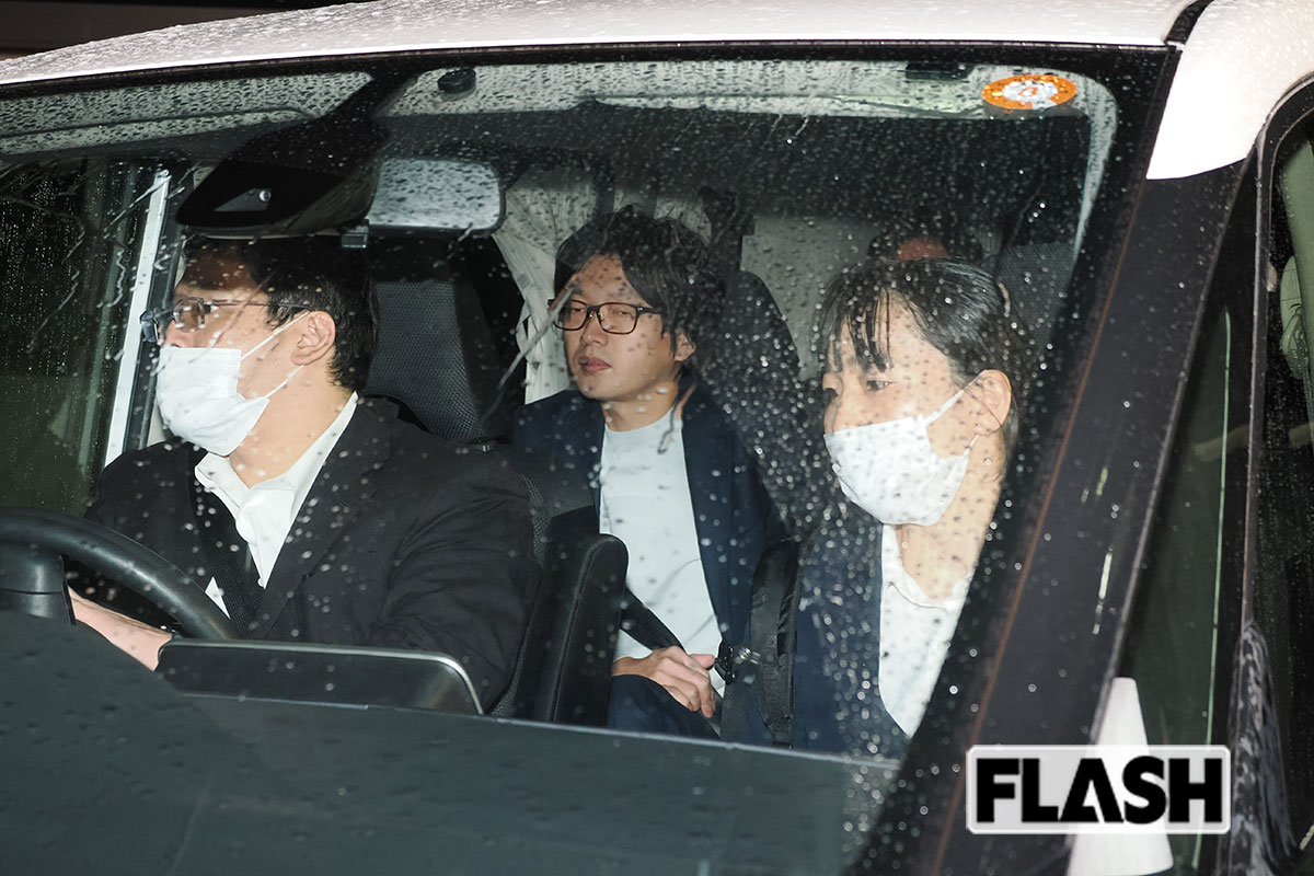 捜査員の車に乗る株式会社アルバトロス代表・谷本慎二社長（写真・梅基展央）