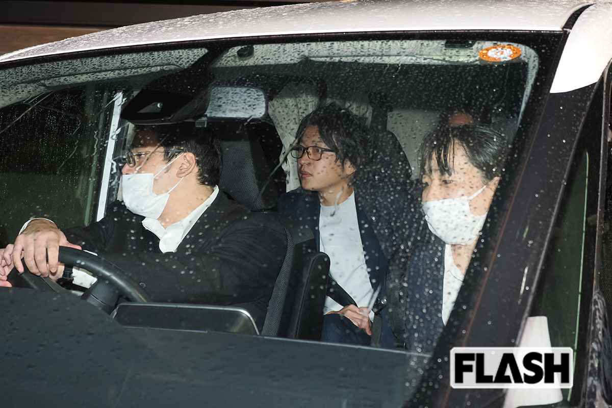 飄々とした表情で捜査員の車に乗る谷本慎二社長（写真・梅基展央）