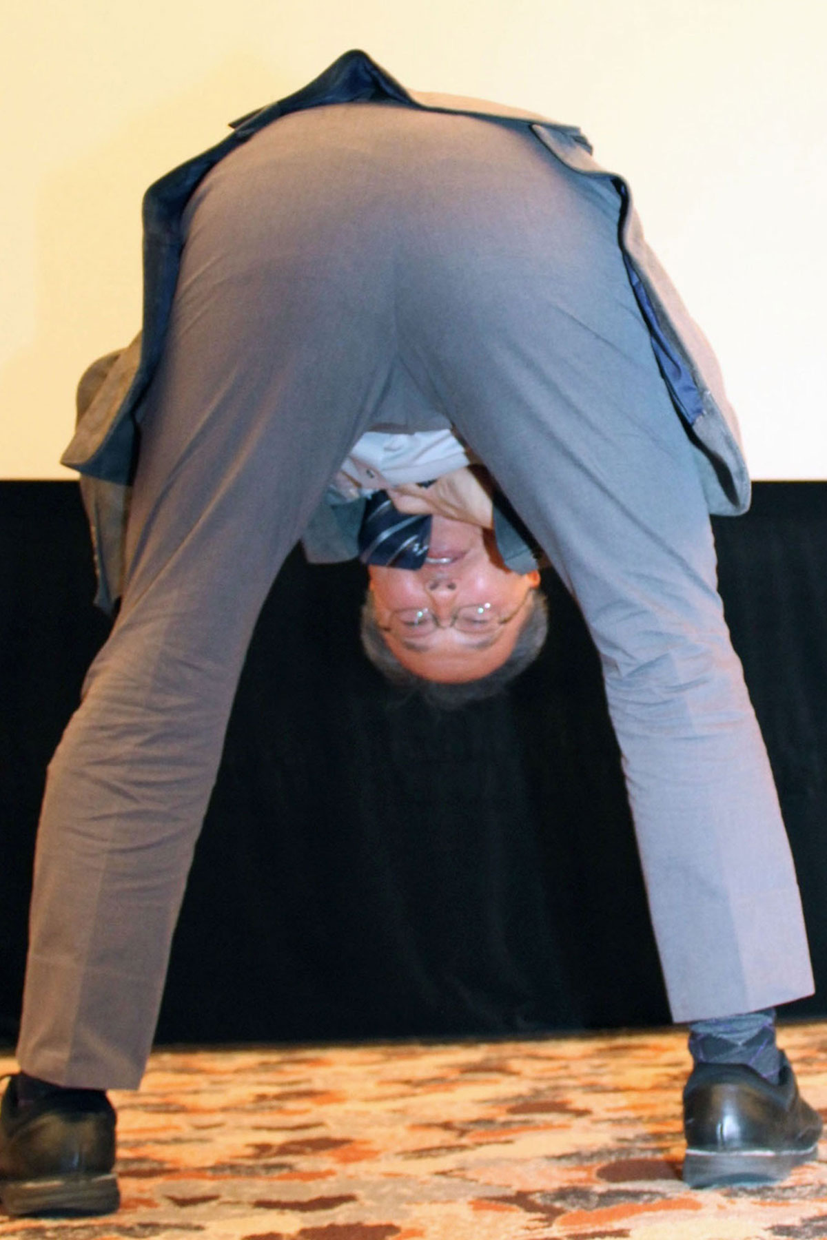 股のぞきを実演する立命館大学の東山篤規教授(写真・共同通信)