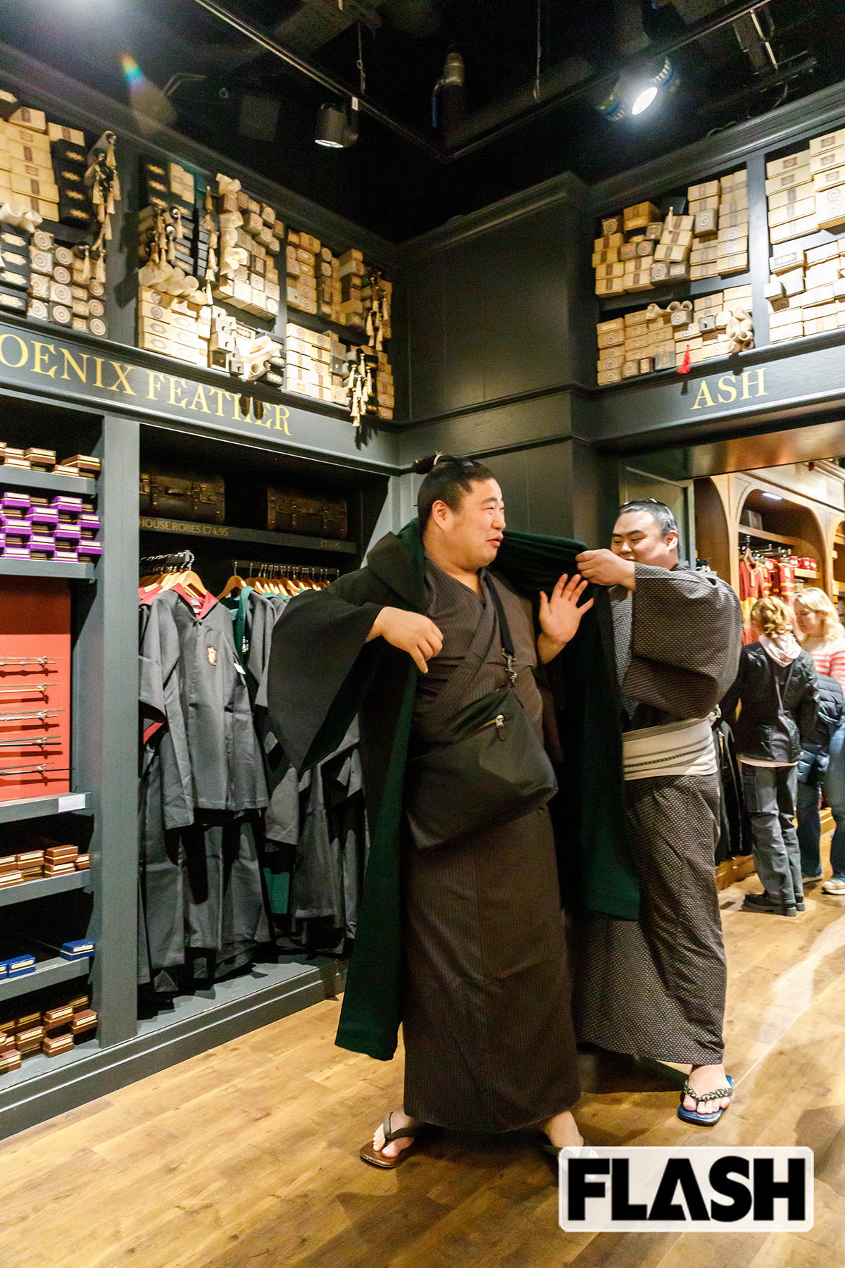 隆の勝の助けを借りてローブを試着する若元春。袖は入りにくいものの、着物の上に重ね着しても違和感なし(写真・高橋マナミ)