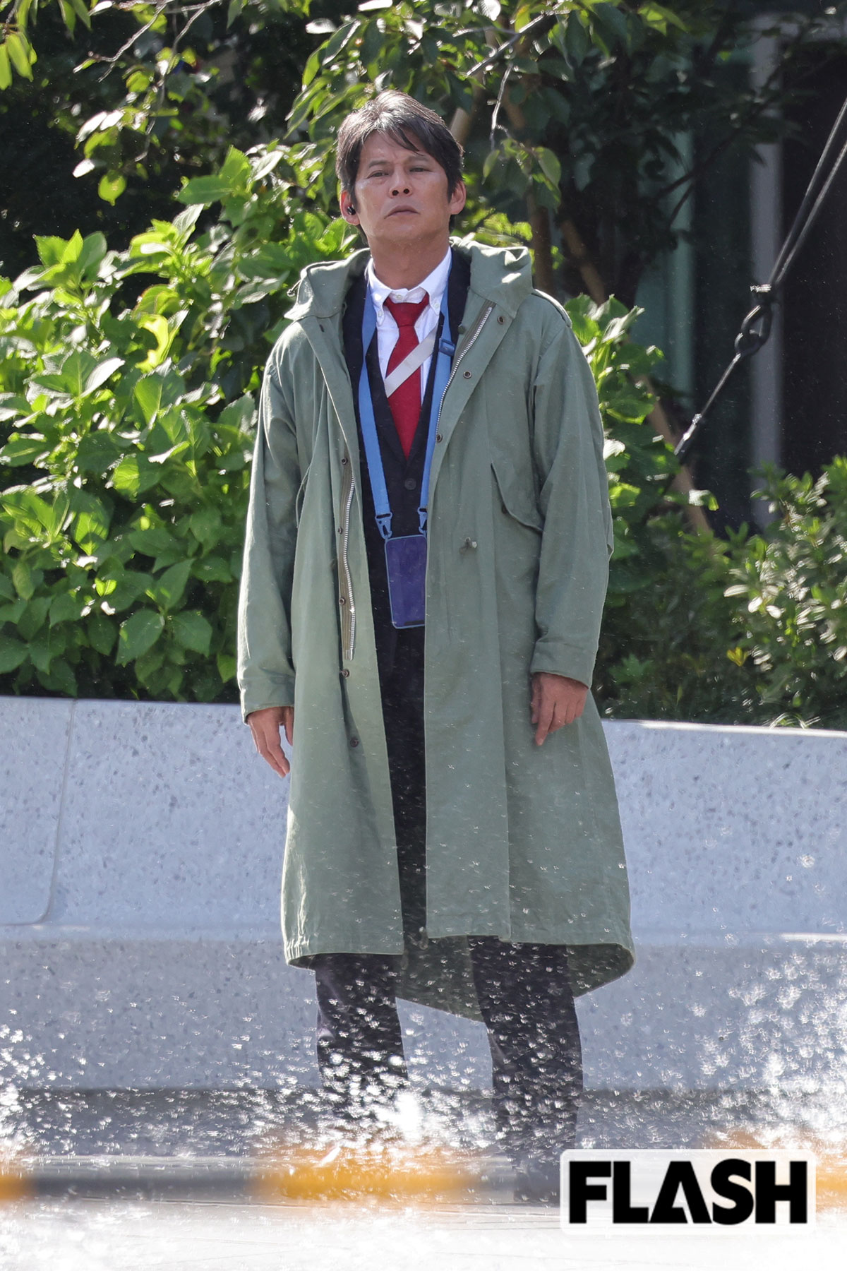 噴水のある広場で立ち尽くす織田裕二