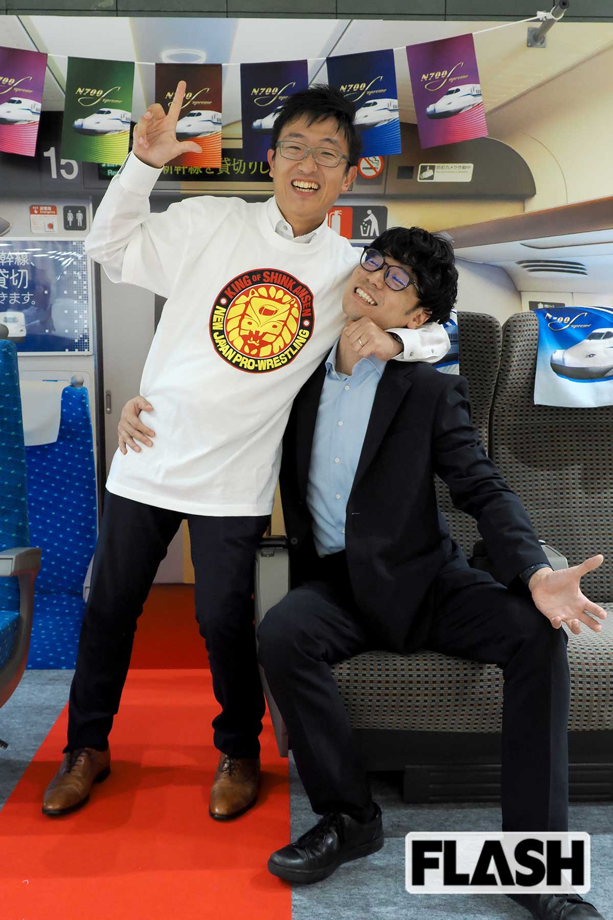 「推し旅」担当の牛田浩之さんは、新日本プロレスと東海道新幹線のコラボTシャツを着ると、おもむろに「貸切車両パッケージ」 担当の森本啓太さんに締め技をしかけた！（写真・梅基展央）