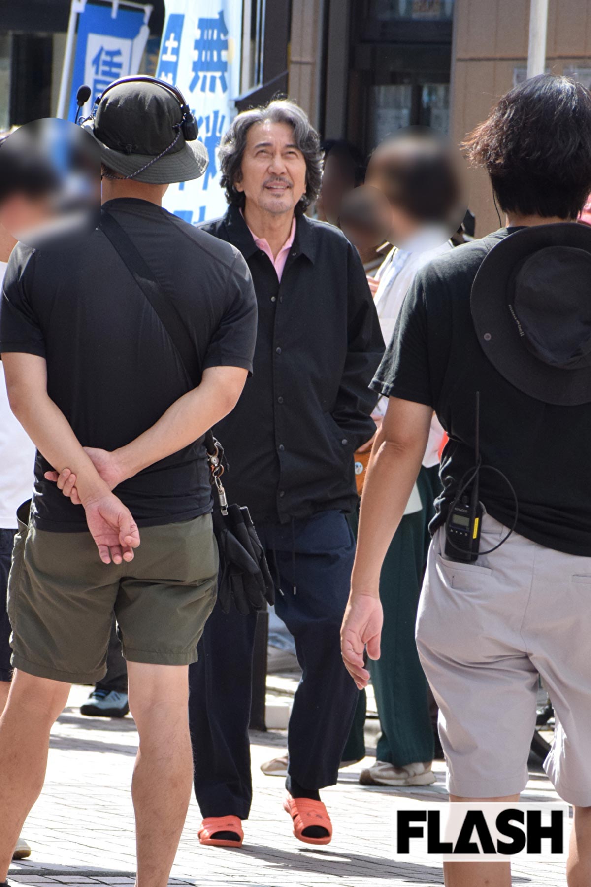 オレンジのサンダルを履いて歩く役所広司