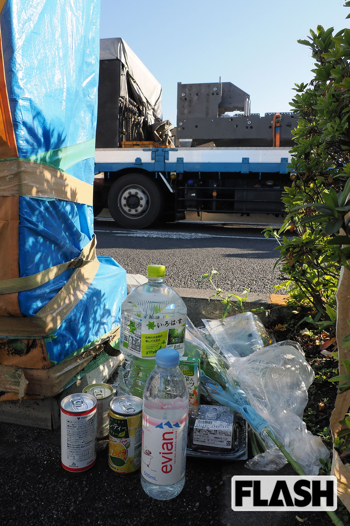 事件現場となった歩道には、亡くなった被害者をしのんで花束や缶ジュースなどが置かれた（写真・梅基展央）