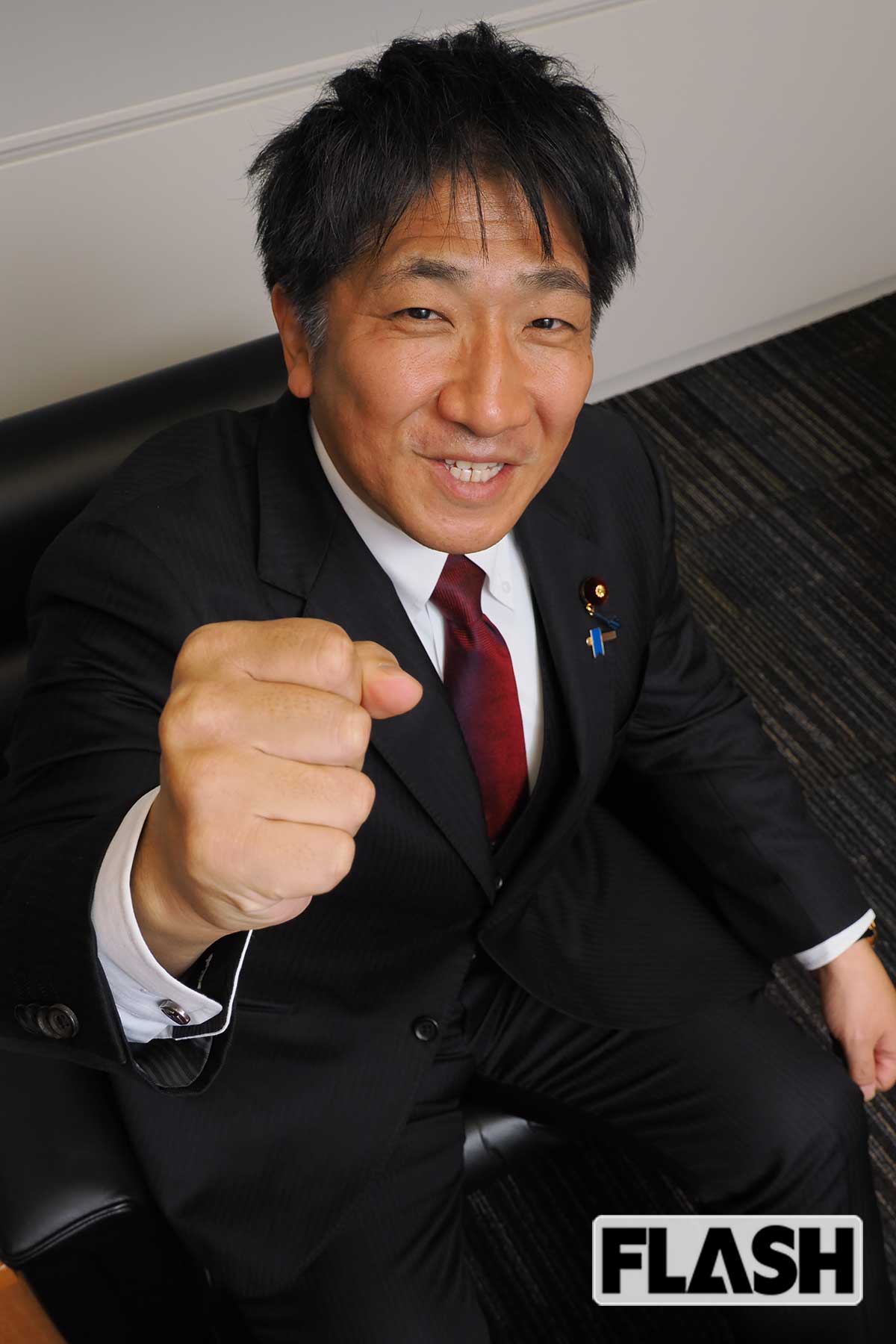 天井に向かってガッツポーズする黒田征樹衆院議員（写真・梅基展央）