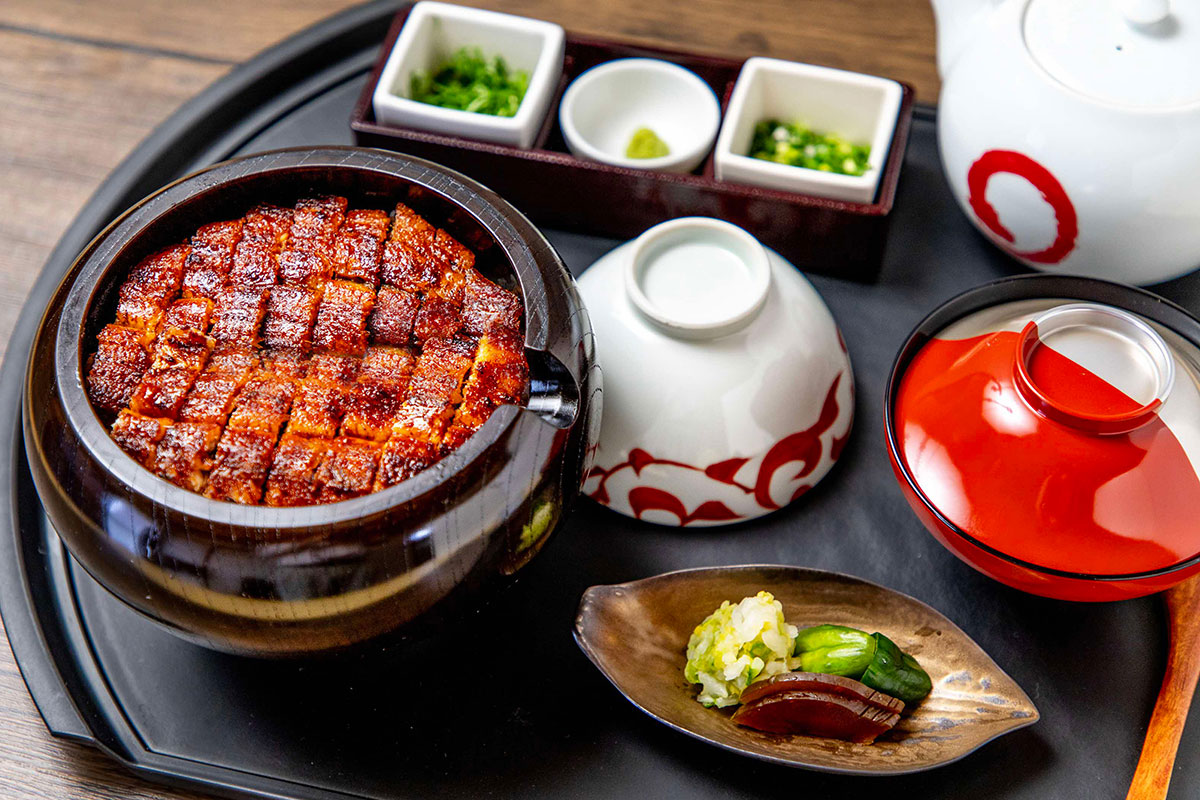 【まるや本店】JR名古屋駅名古屋うまいもん通り　太閤通口・営業時間／11:00～22:00（L.O. 21:30）年中無休。うなぎ職人がじっくり焼いたうなぎを目当てに、地元民が行列するひつまぶし専門店。JR名古屋駅構内の新幹線改札近くの「名古屋うまいもん通り」にあり、アクセスは抜群。店内はテーブル席を中心に、出張などのおひとり様でも落ち着いて食事ができるカウンター席もある。