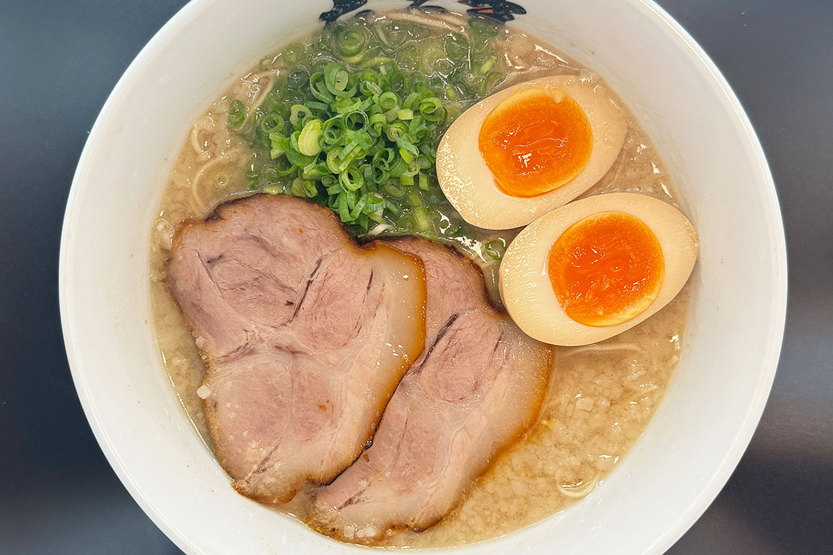 【元祖博多だるま】博多めん街道・営業時間／10:00～23:00（L.O. 22:30）年中無休。1963年の創業以来、新しいスープを古いスープに注ぎ足して作る伝統の味を守り続ける名店。カウンター中心の店内で、これぞ “THE博多ラーメン” といえる、濃厚かつ鮮烈な豚骨スープを堪能できる。