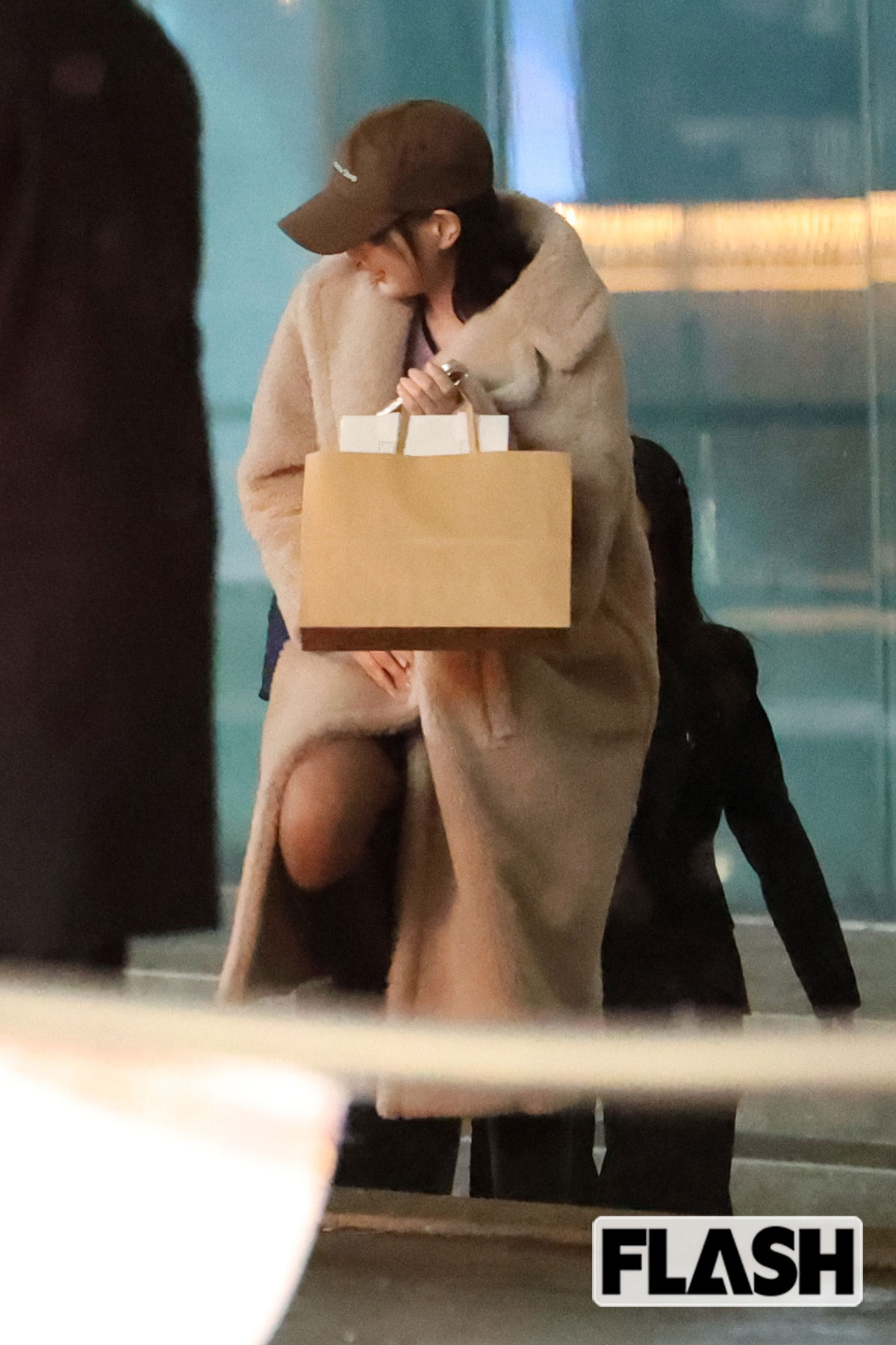 美しいコートを着こなす本田翼。MISAMOの“推し活”帰りだ。ミニスカートの隙間からはさすがの美脚がチラり