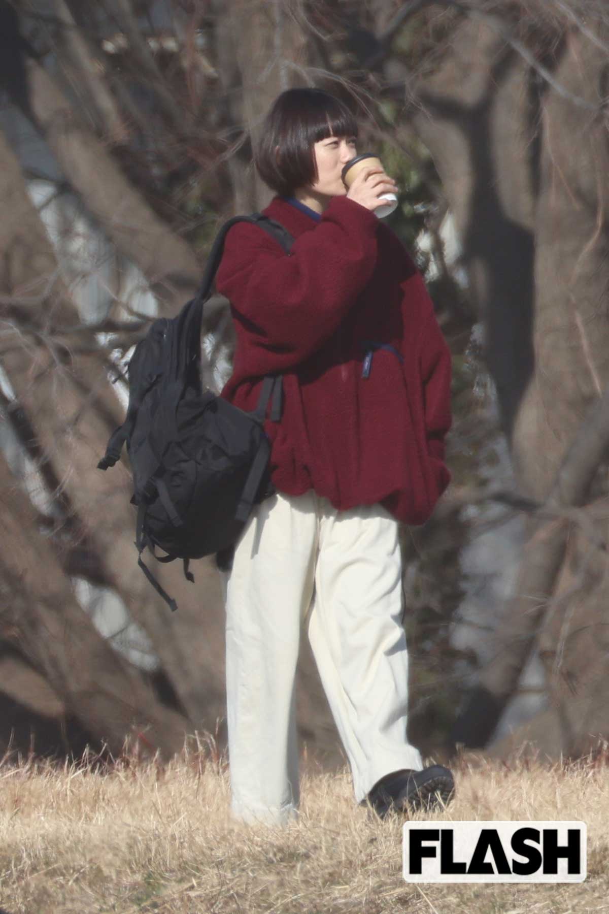 リュックをかけて、ドリンクを飲む杉咲花