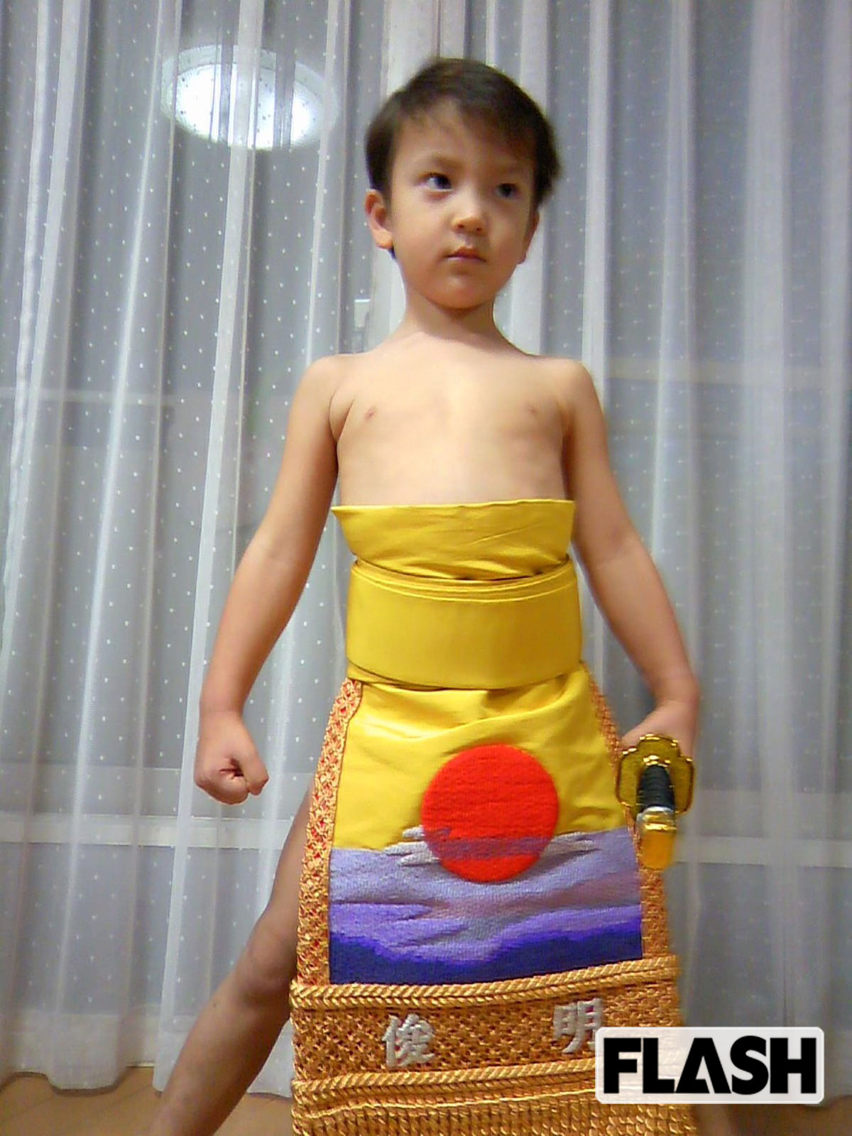 幼稚園のとき、お父さんの化粧まわしをつけてポーズを取る嵐翔真