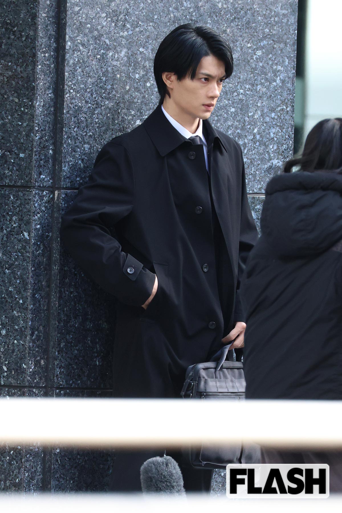 スーツ姿にコートを羽織った佐野勇斗