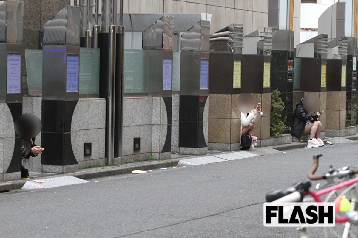 ラブホテルの外壁に座っている立ちんぼ女子たち（写真・金谷千治）