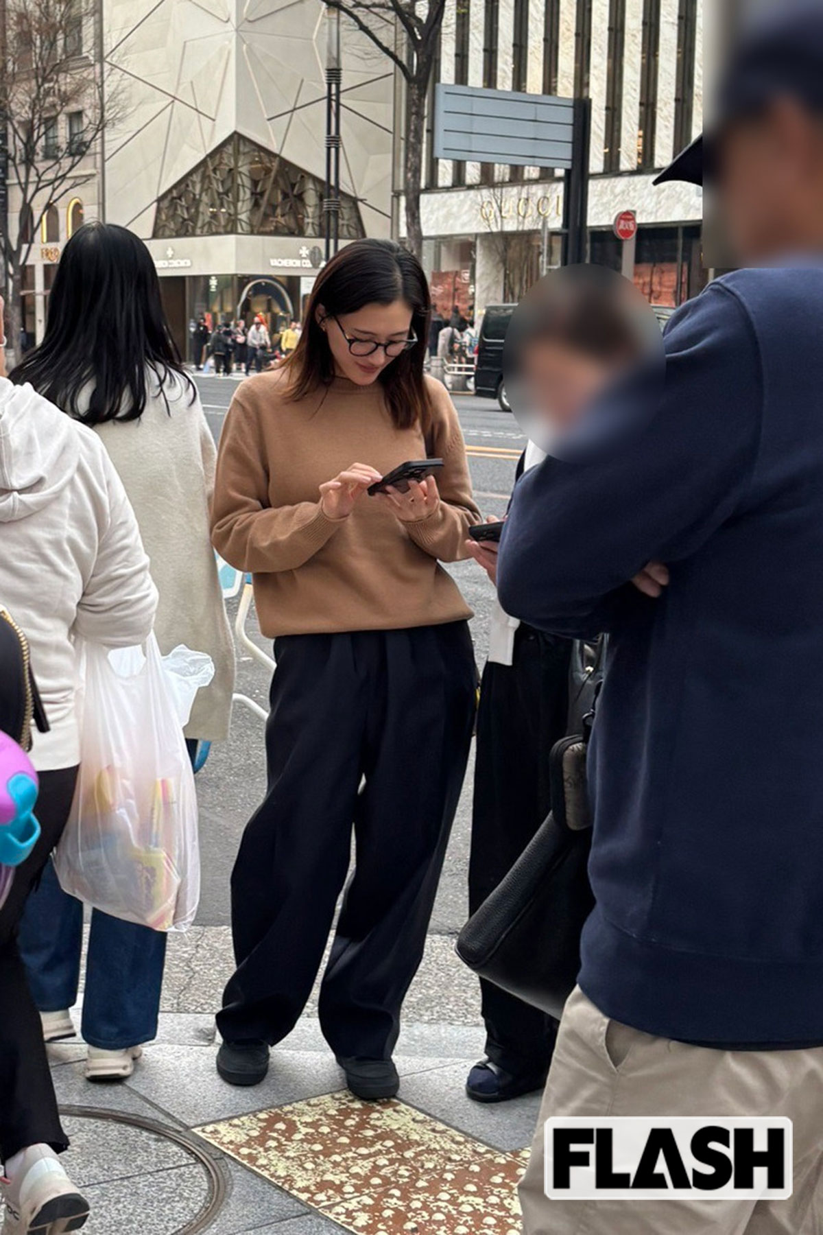 通行人の多い歩道でスマホを操作している綾瀬はるか