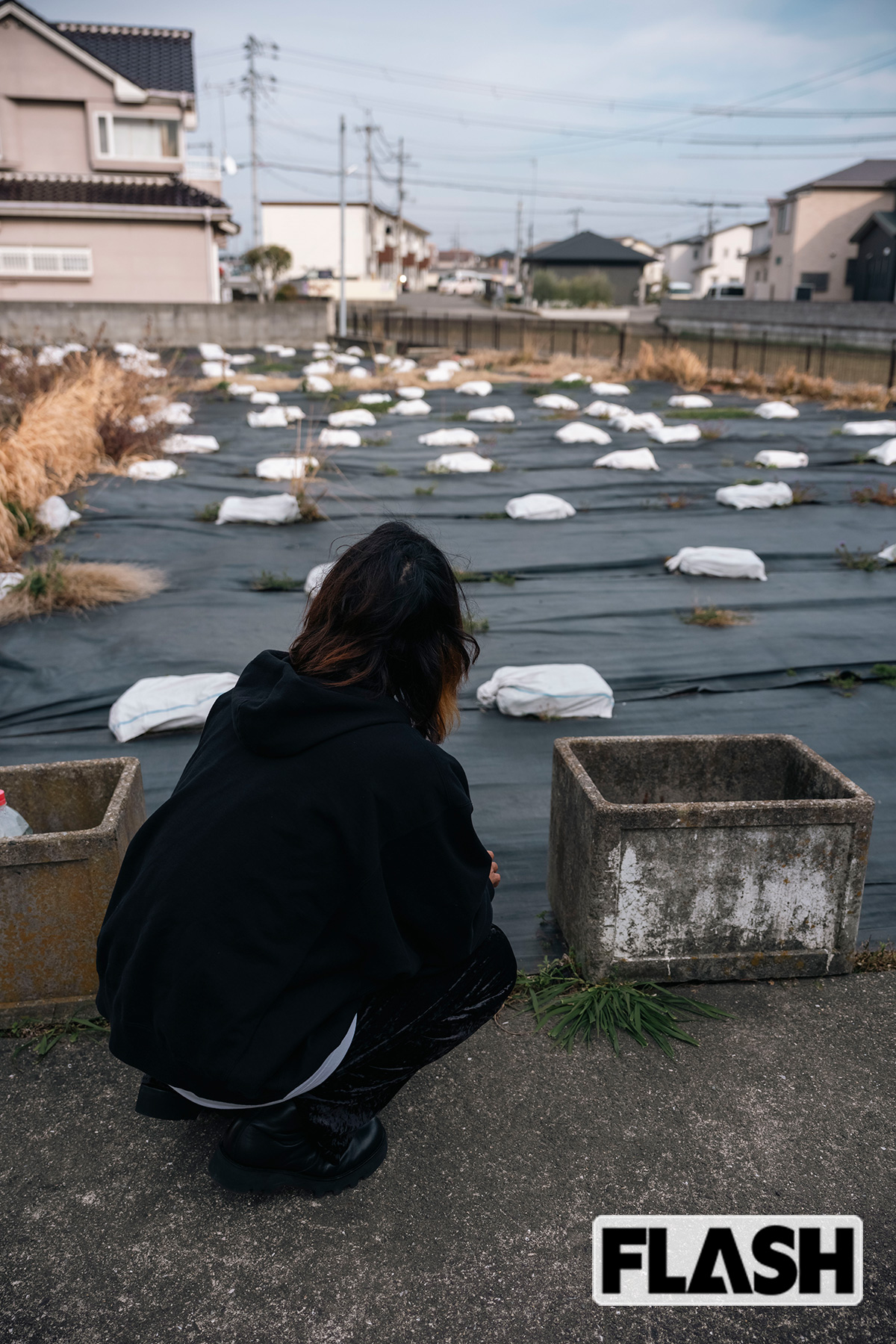 林氏（長男）は自宅の跡地にしゃがみ込んだ（写真・木村哲夫）