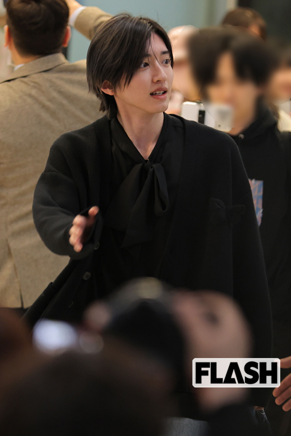 混雑する空港内を歩く道枝駿佑