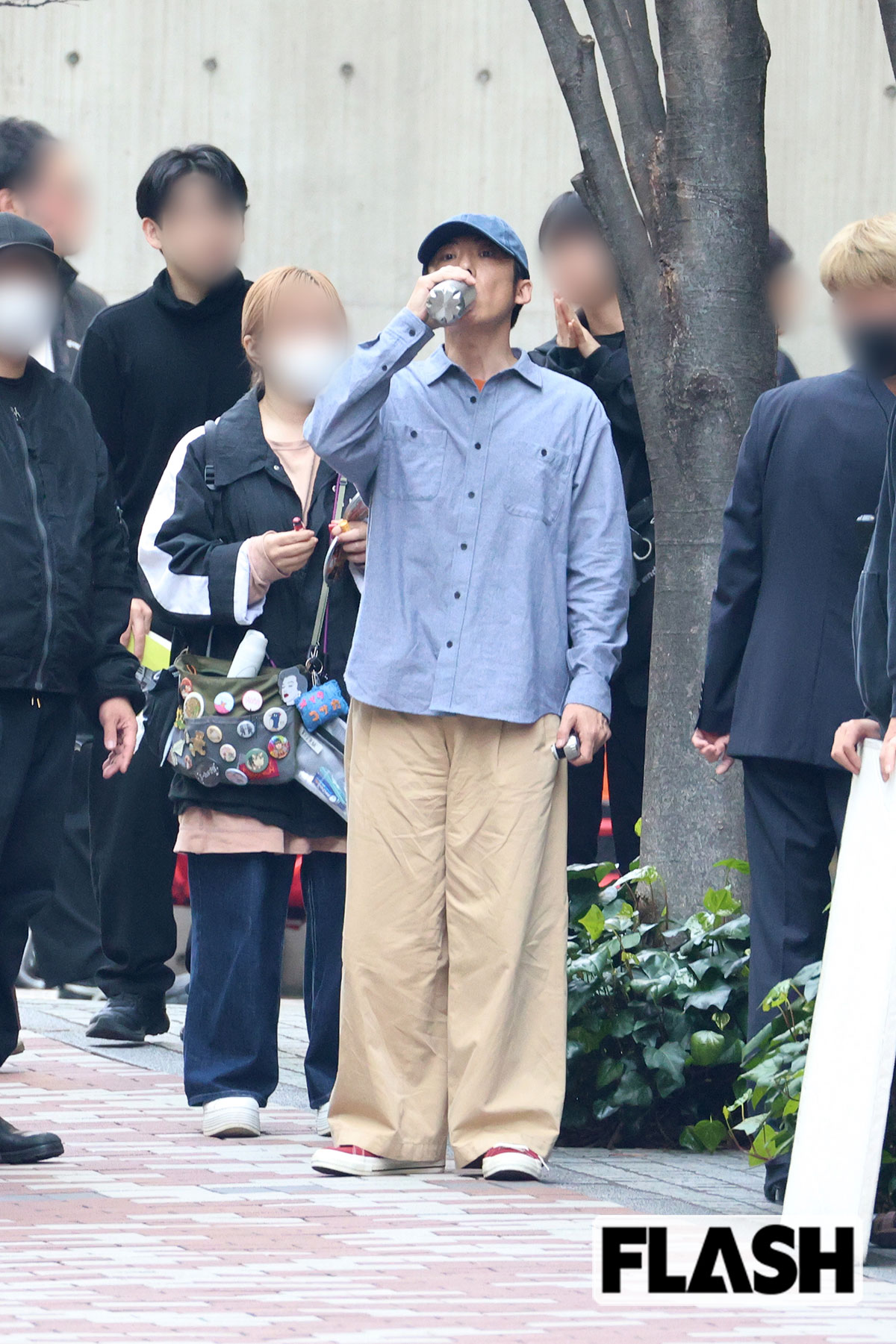 撮影の待機中に飲み物を飲む高橋一生