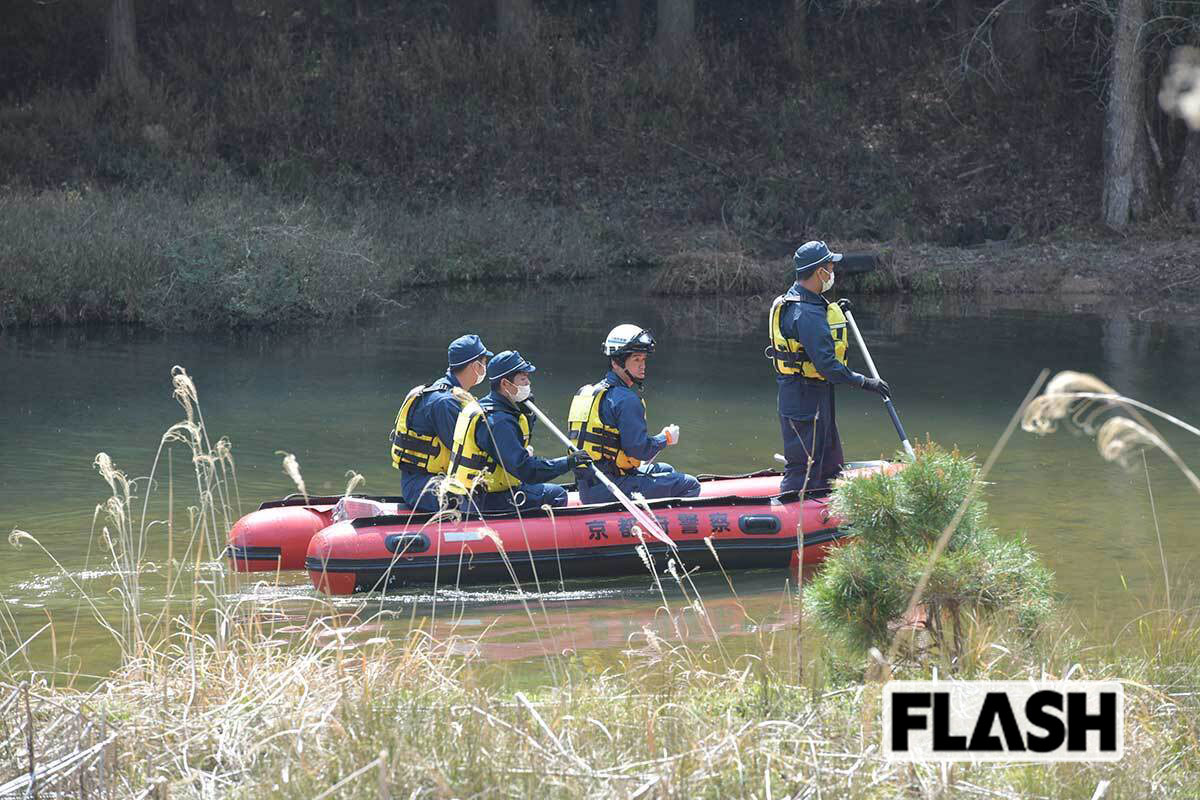 ゴムボートにのって付近のため池を捜査する警察関係者（写真：馬詰雅浩）