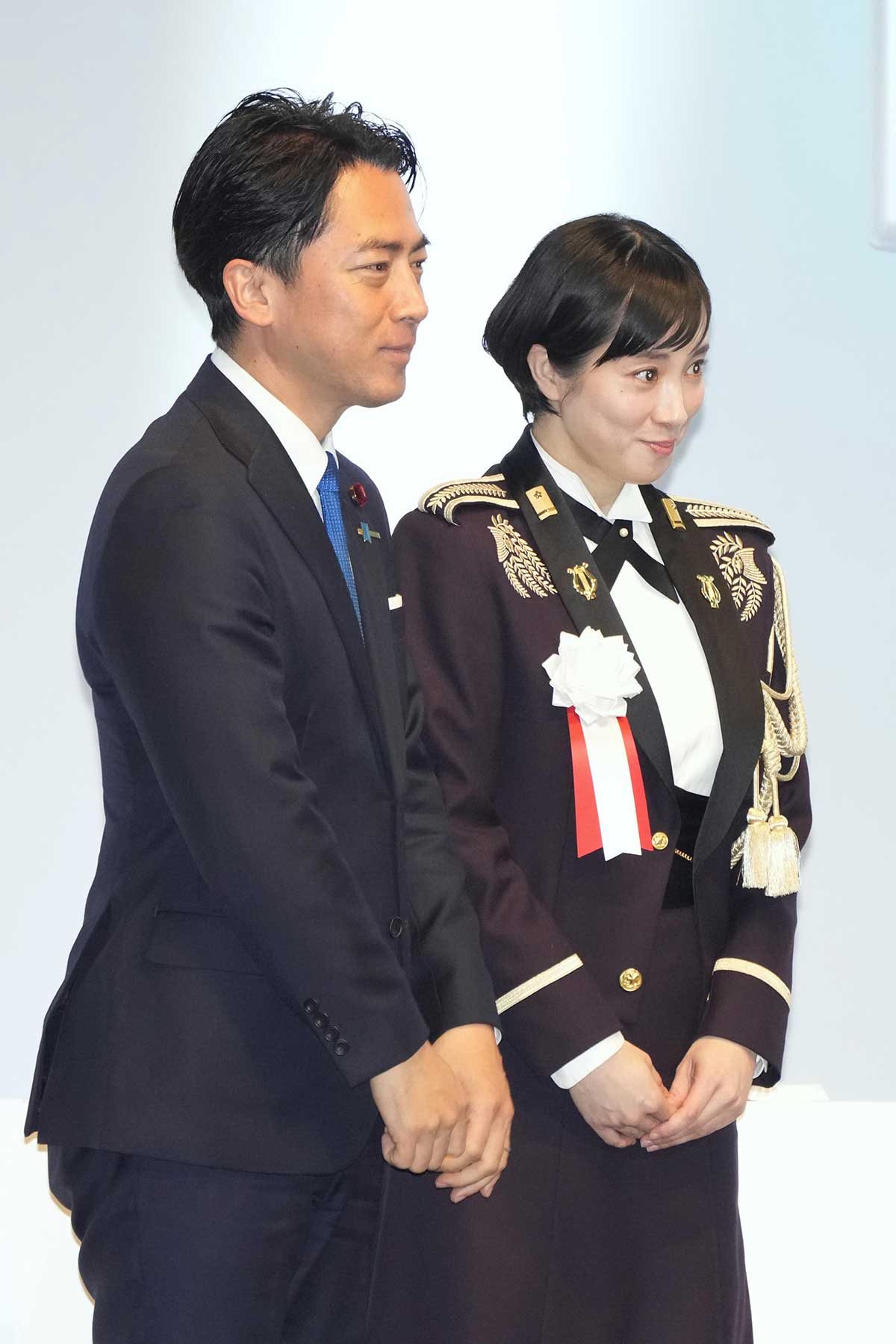 自民党大会で制服姿で国歌斉唱をおこなった鶫（つぐみ）真衣3等陸曹（右）。政治的な中立性をめぐり議論となっている（写真・共同通信）