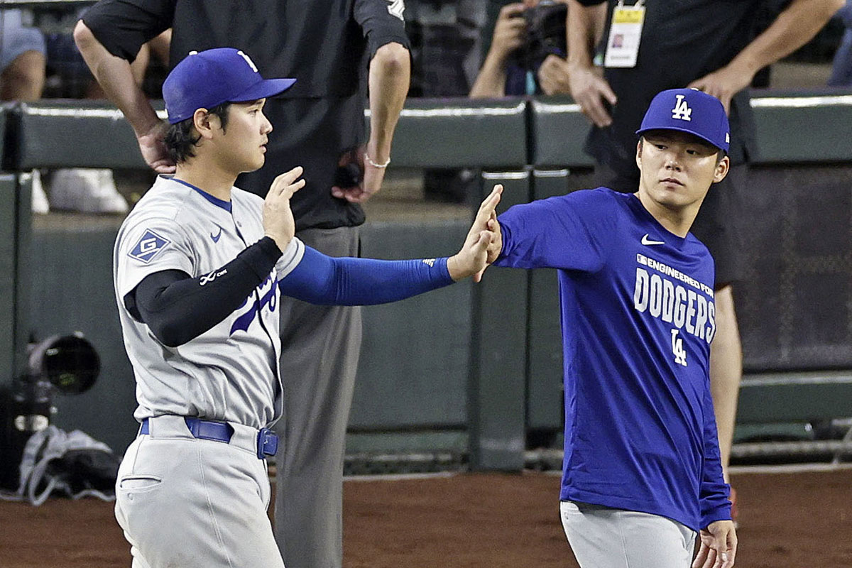 ダイヤモンドバックスに勝利し、チームメイトの山本由伸とハイタッチを交わす大谷翔平（写真・共同通信）