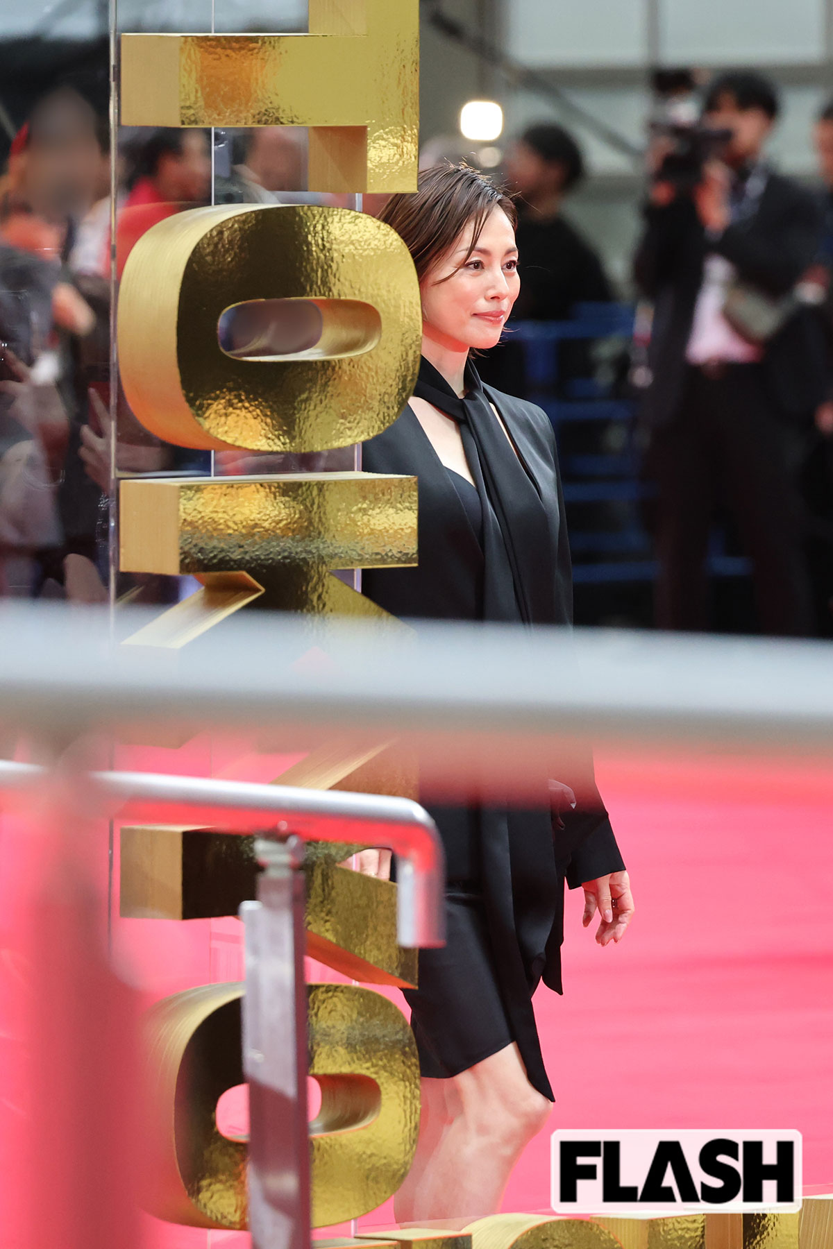 黒のセットアップを着こなす米倉涼子。ミニ丈のスカートからはさすがの美脚をのぞかせている