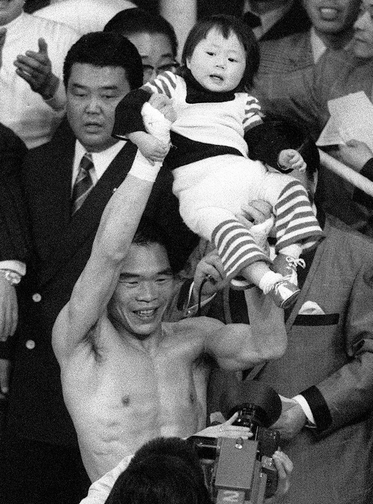 1歳8カ月になる娘の有紀ちゃんを高々と抱き上げてスタンドの声援に応えるガッツ石松さん（写真・共同通信）
