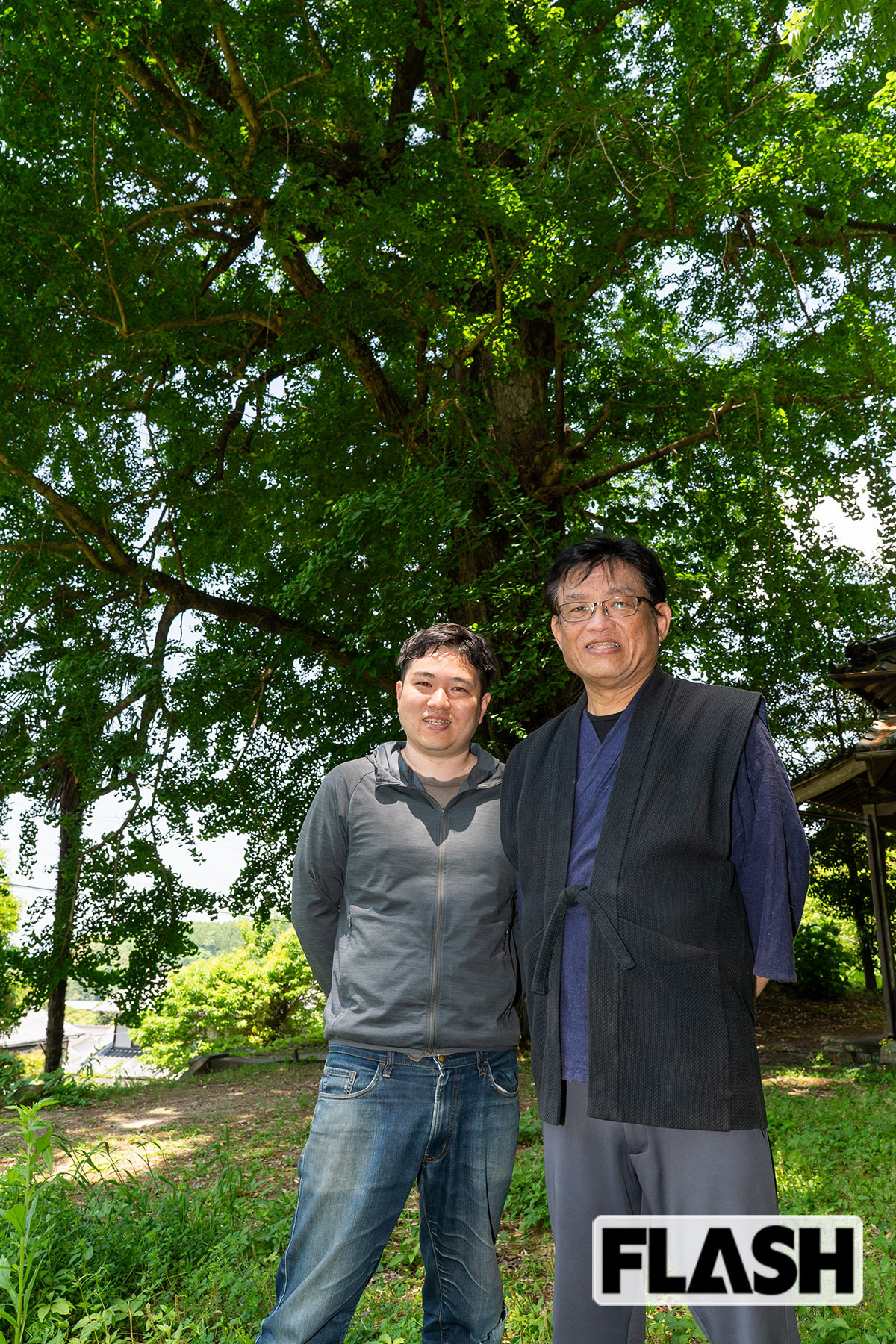 「鍋島藩窯 市川光山窯」の工房の裏に佇む樹齢数百年の大銀杏を前に、市川光山さんと20代目を継ぐ予定の息子の浩光さん（写真・駄道賢剛）