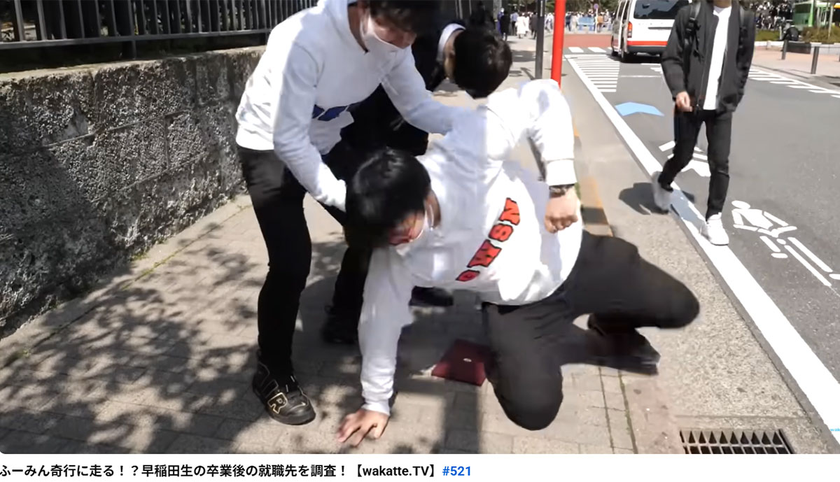 2021年、早稲田大学の卒業式で学生から就職先を聞く動画を公開した学歴系YouTuber「wakatte.tv」。メンバーの高田ふーみんが男子学生の卒業証書を踏みつけていた。このシーンが物議をかもしている(wakatte.tvのYouTubeチャンネルより)