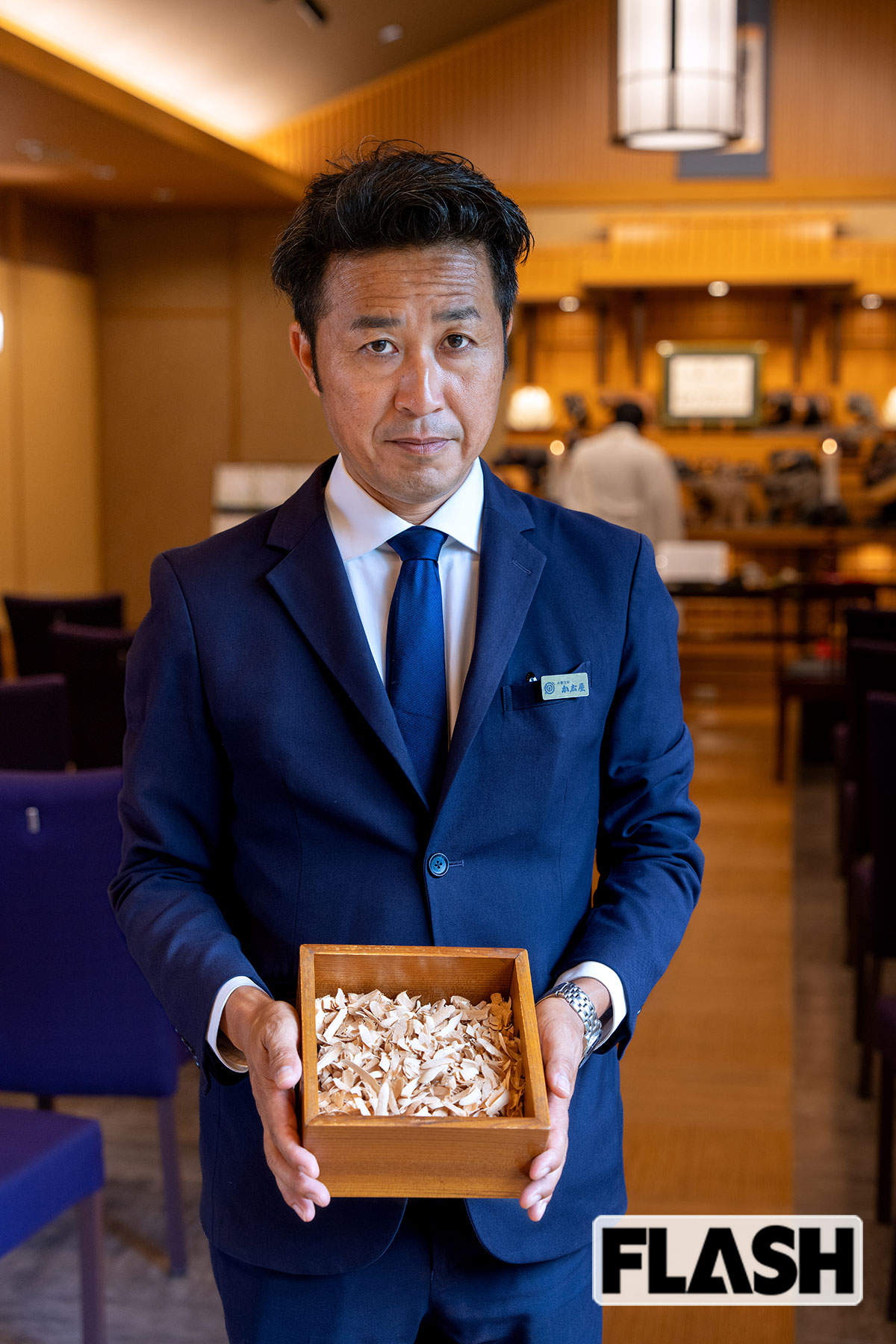 山に撒くウッドチップの見本を持つ平野清隆氏（写真・福田ヨシツグ）