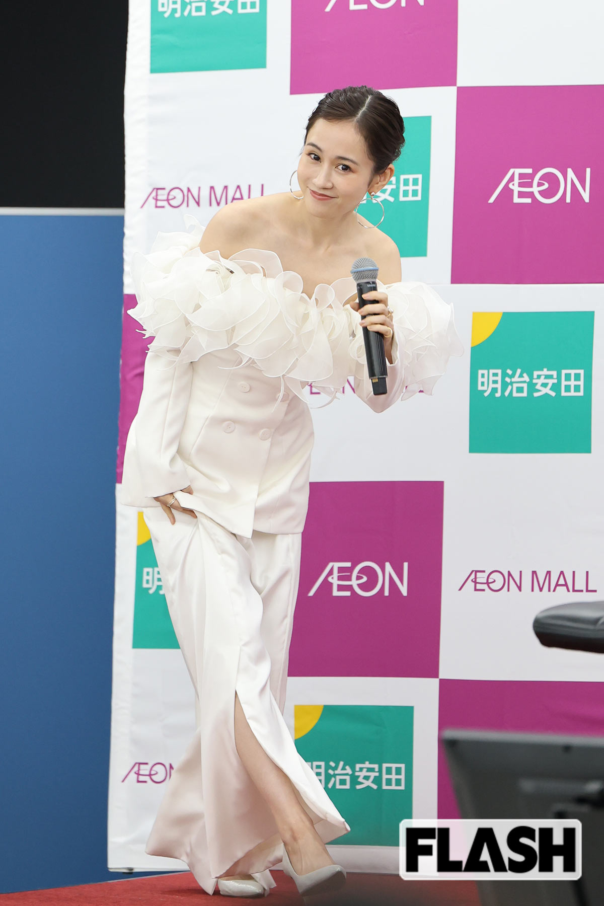 マイクを片手に独特なシルエットのドレスで登壇する前田敦子