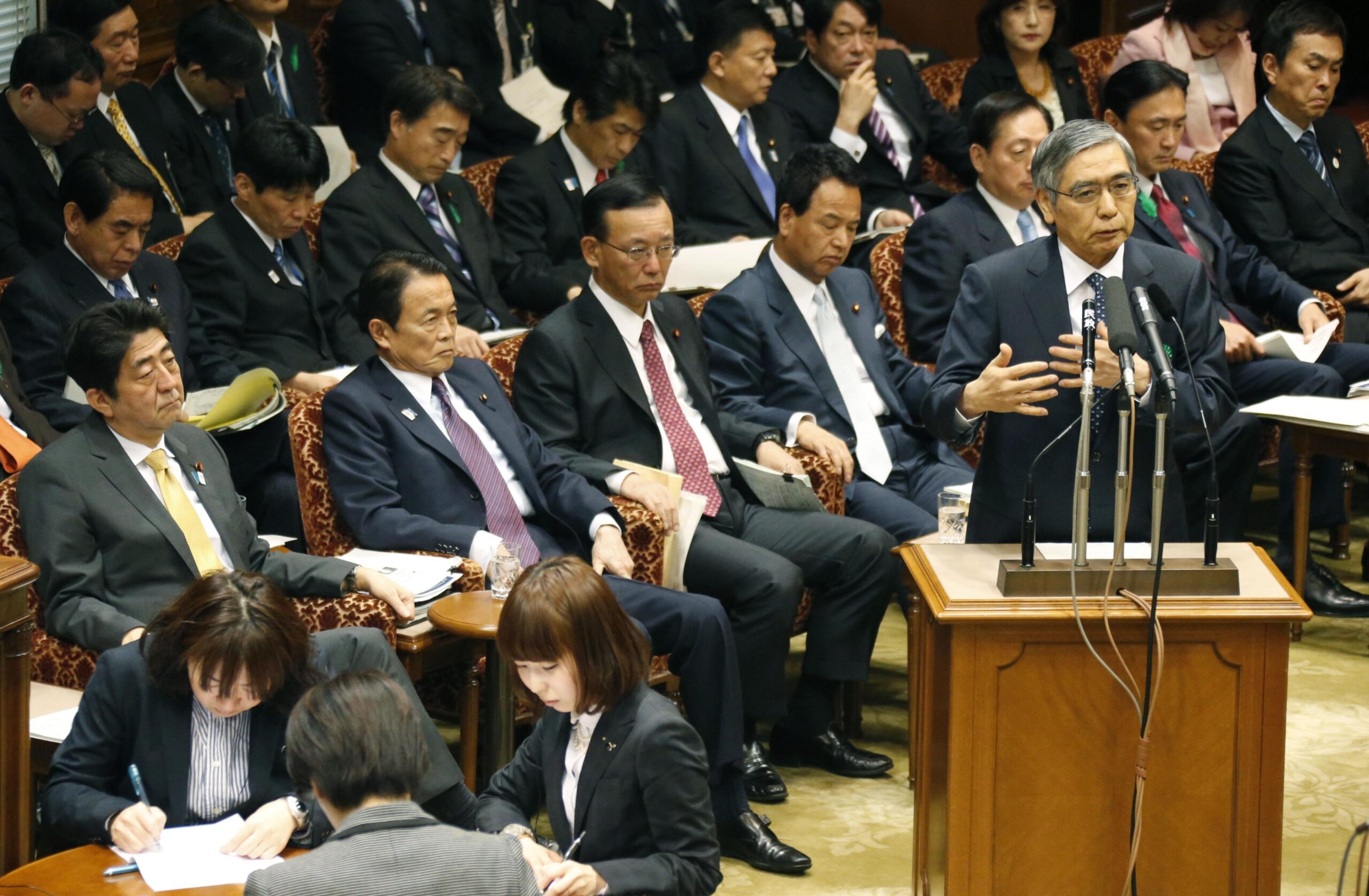 「黒田バズーカ第1弾」直後の参院予算委で答弁する黒田氏。左端に安倍晋三元首相の姿が見える（写真・共同通信）